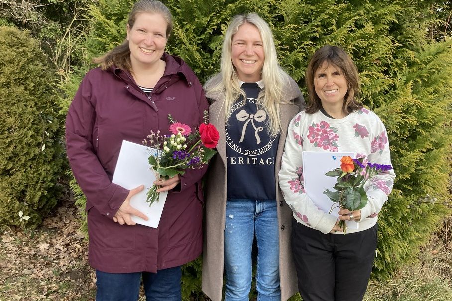 Erfreut nehmen Marjam Gues (links) und Jeanette Pfeifer (rechts) ein buntes Sträußchen zur Begrüßung entgegen. In der Mitte Kathrin Trackl, Leiterin im Waldkindergarten.