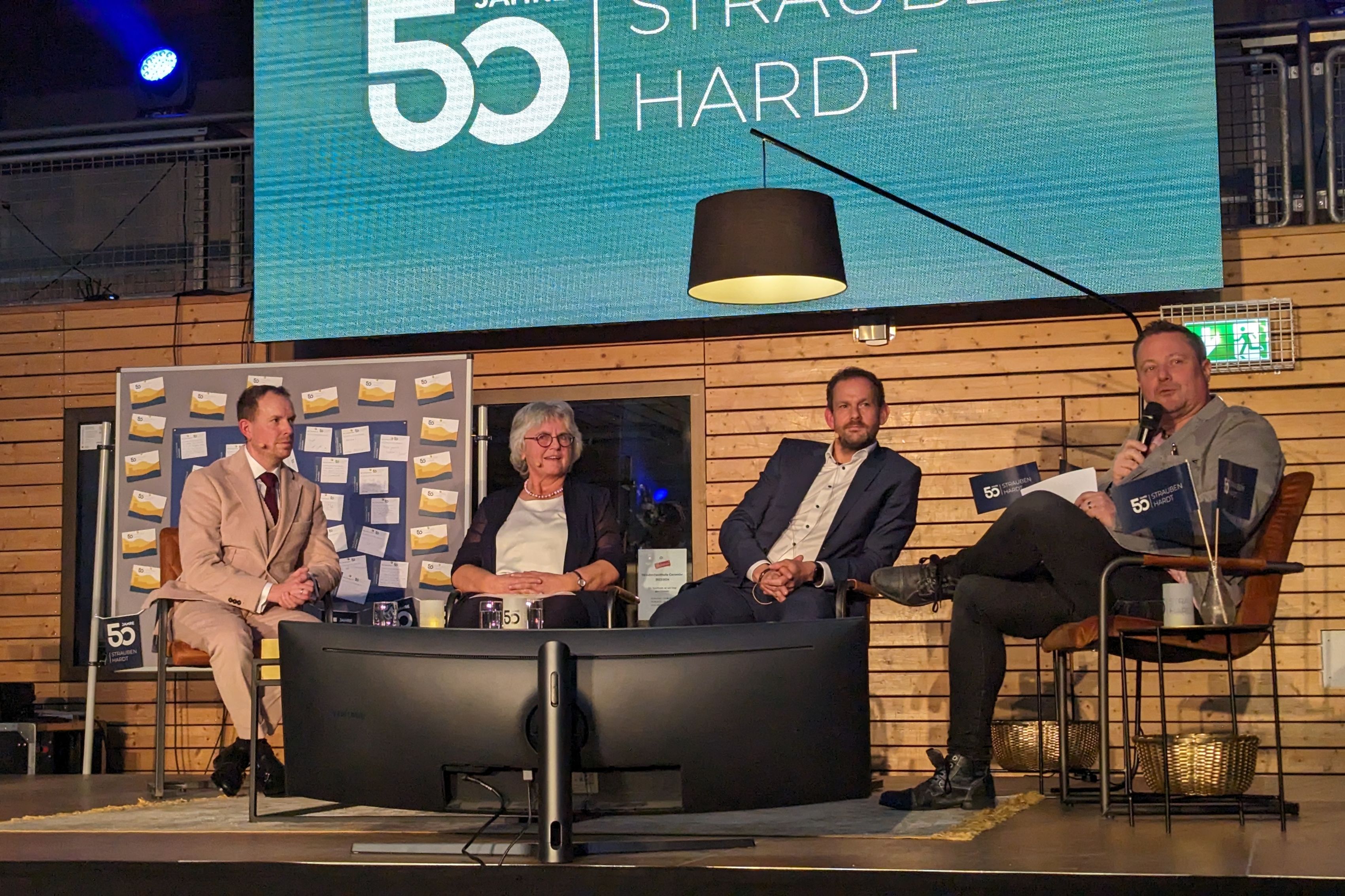 Auf einer Bühne im Wohnzimmer-Look, ausgestattet mit Retro-Stühlen, Stehlampe und Teppich der Wohnidee, unterhielt sich Kochhann mit Landrat Bastian Rosenau, Gemeinderätin Erna Grafmüller und Bürgermeister Viehweg