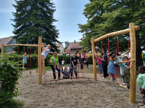 Gemeinsam mit den Kindern begutachten Barbara Drollinger (Abteilung Bildung, Familie und Kultur), Kerstin Föll (Leiterin der Kita Kunterbunt) und Saskia Toth (Stellvertretende Leitung) das neue Spielgerät (von links). 