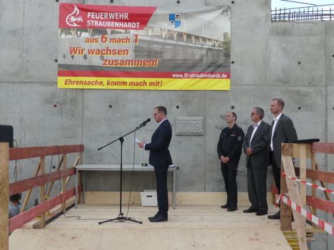 Bürgermeister Helge Viehweg (links) vor dem Grundstein, der eine Zeitkapsel für die Nachwelt abdeckt. Foto: Gemeinde