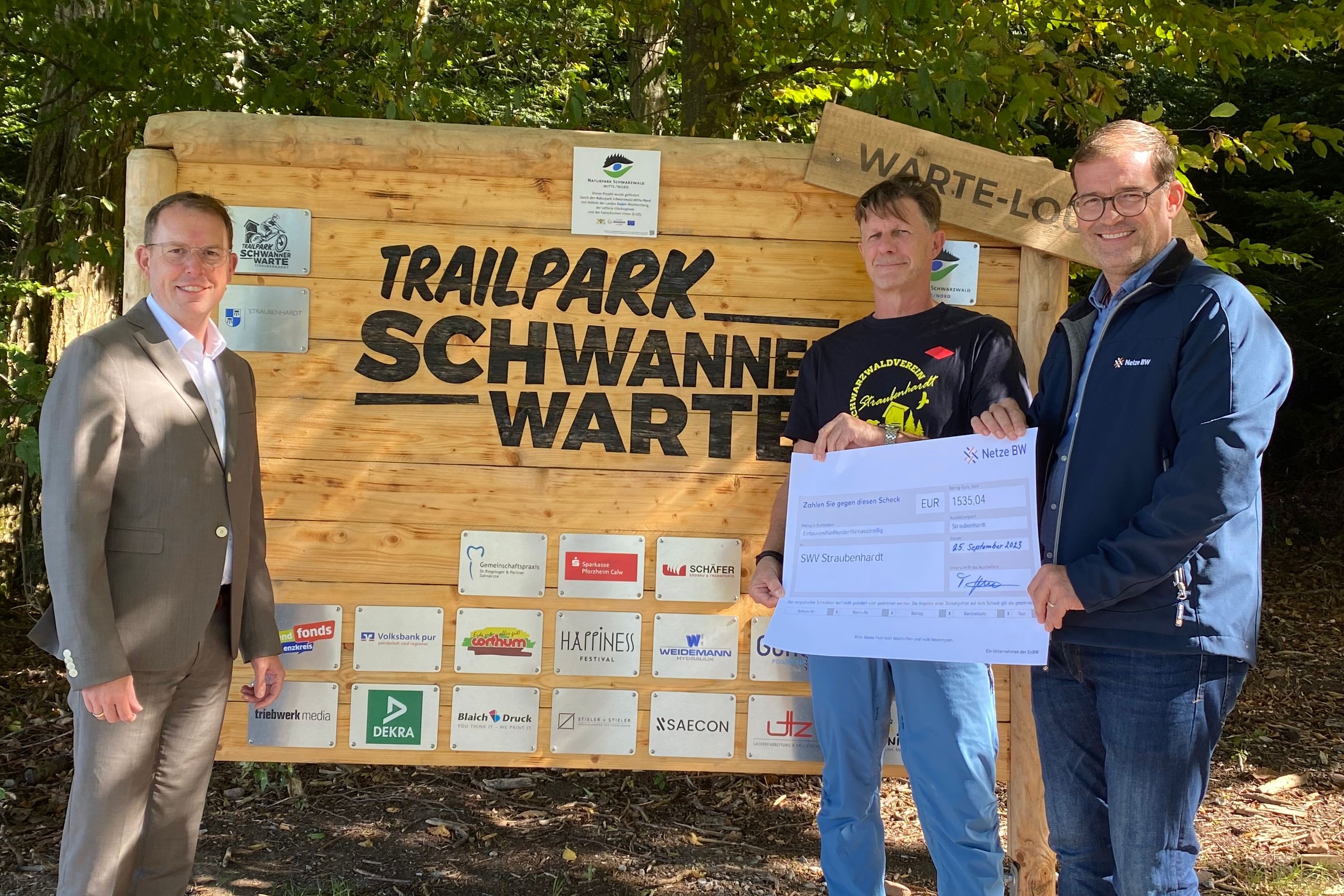 Tino Stutz ( Kommunalberater der Netze BW) überreicht Frederic Trautz (Vorsitzender des Schwarzwaldverein Straubenhardt) den Spendenscheck, Bürgermeister Helge Viehweg lobt die Aktion (von rechts)